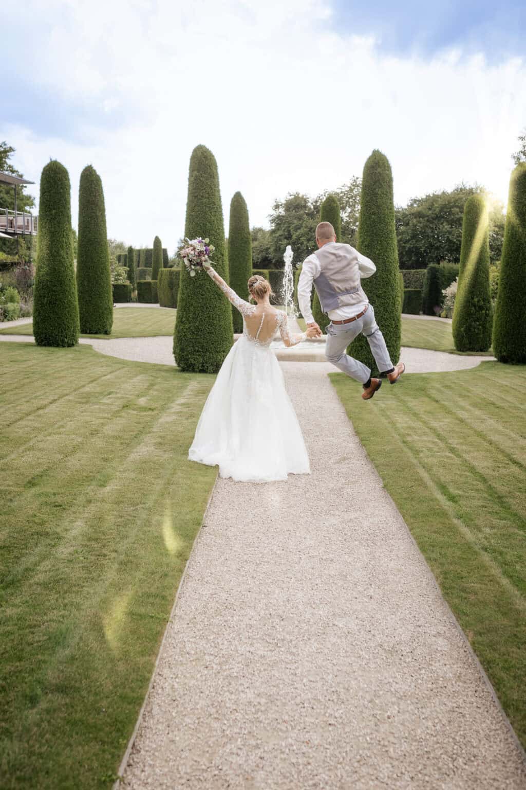 Hochzeitsfotograf in Freudenstadt - Hochzeitspaar jubelt im Garten, Bräutigam springt vor Freude in die Luft