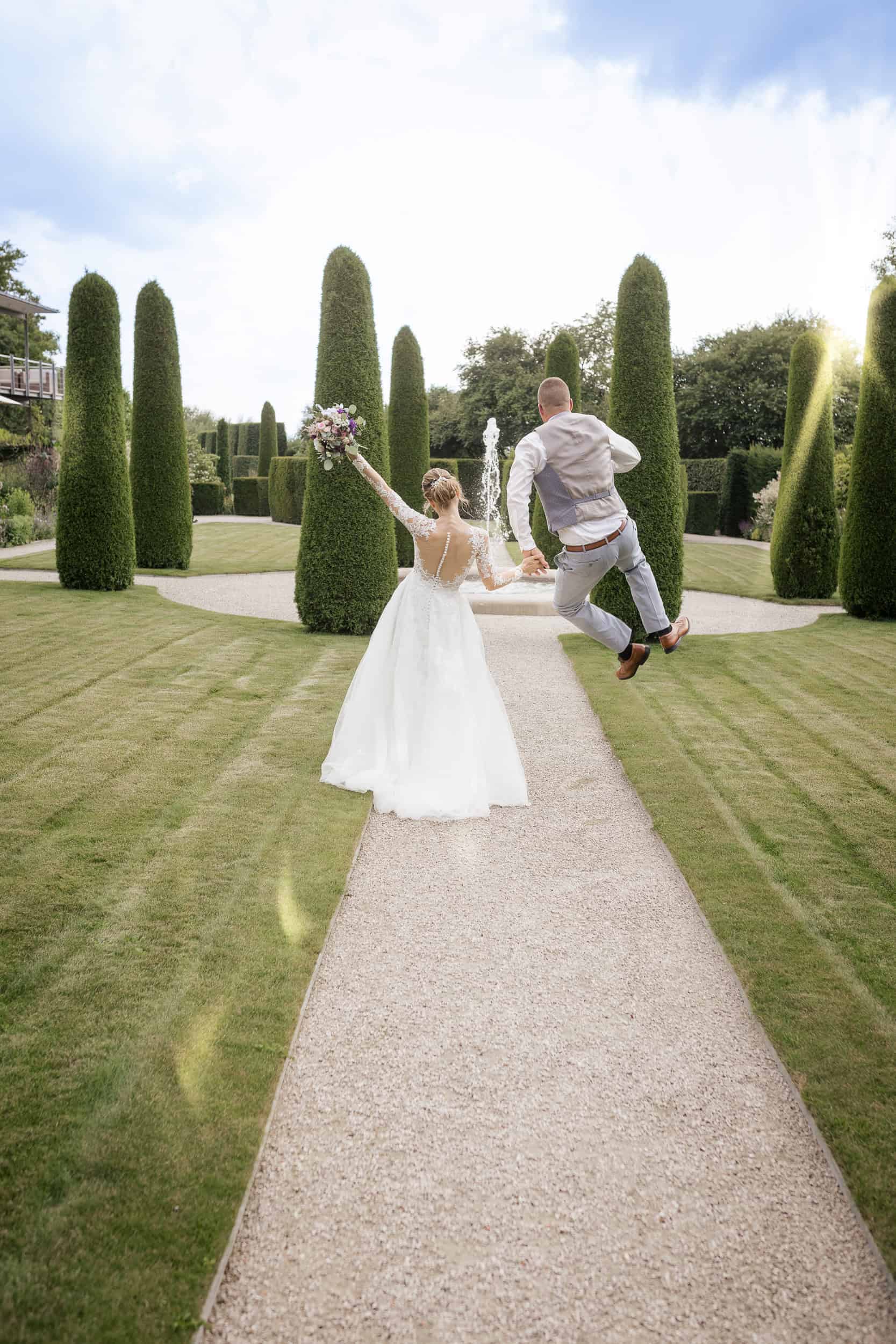Hochzeitsfotograf Tübingen -brautpaar läuft fröhlich durch Gartenanlage, Bräutigam springt jubelnd in die Luft. Hochzeitsfotograf Tübingen -brautpaar läuft fröhlich durch Gartenanlage, Bräutigam springt jubelnd in die Luft.