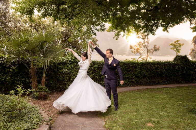 Brautpaar tanzt im Garten mit Blick auf Berge – emotionale Hochzeit am See