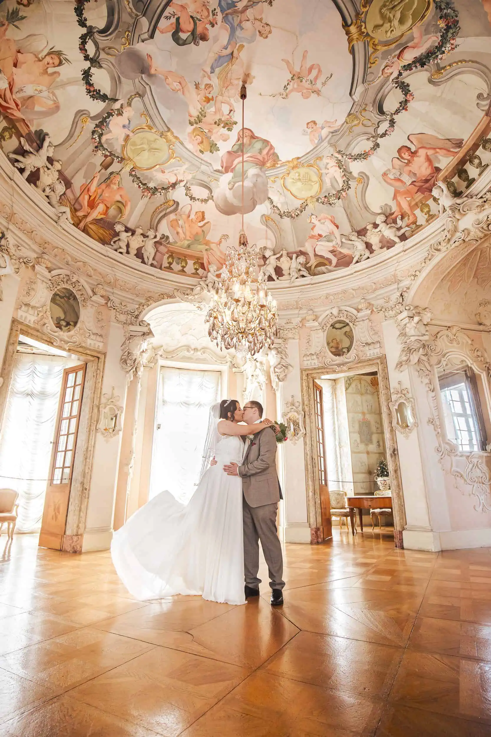 Hochzeitsfotograf Empfehlung Stuttgart Brautpaar küsst sich im barocken Festsaal – elegante Hochzeitsfotos in Schlossatmosphäre