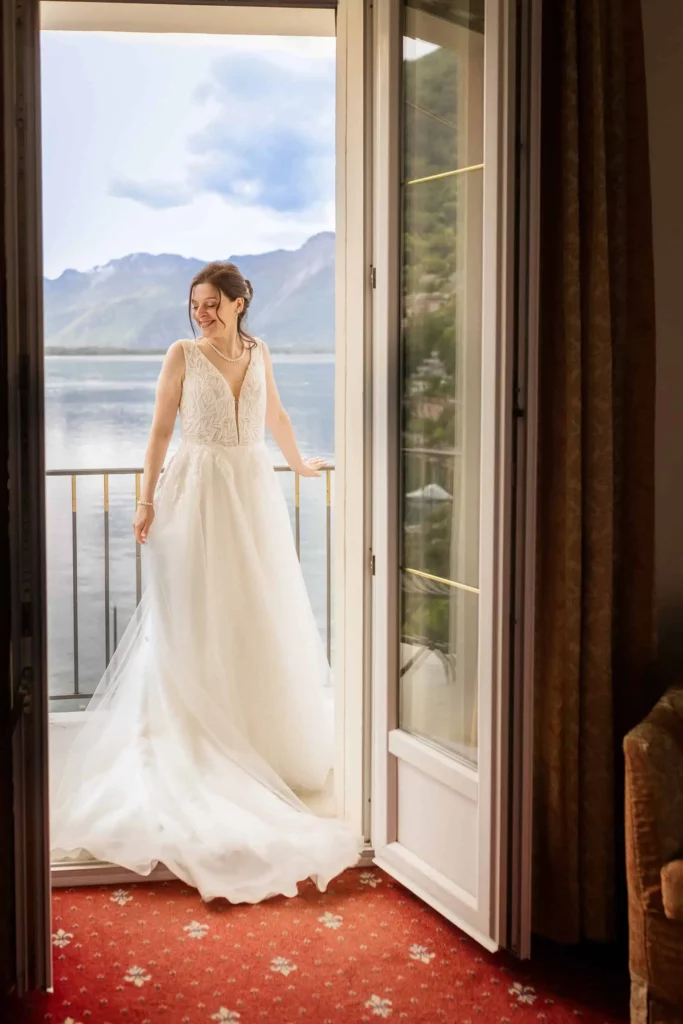Braut auf dem Balkon mit Blick auf See und Berge – elegante, natürliche Hochzeitsfotografie