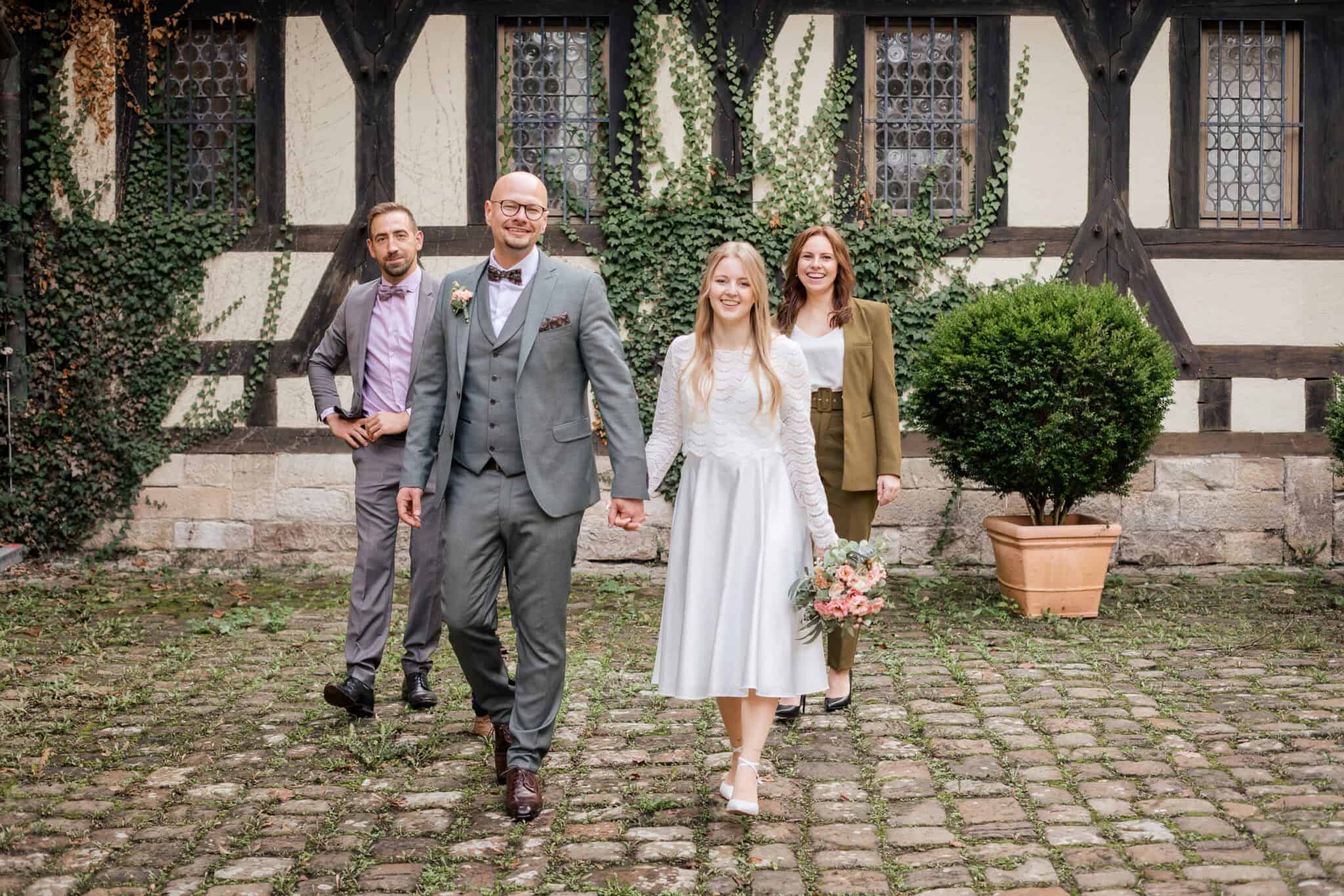 Hochzeitspaar mit Gästen vor Fachwerkhaus bei standesamtlicher Trauung in Tübingen